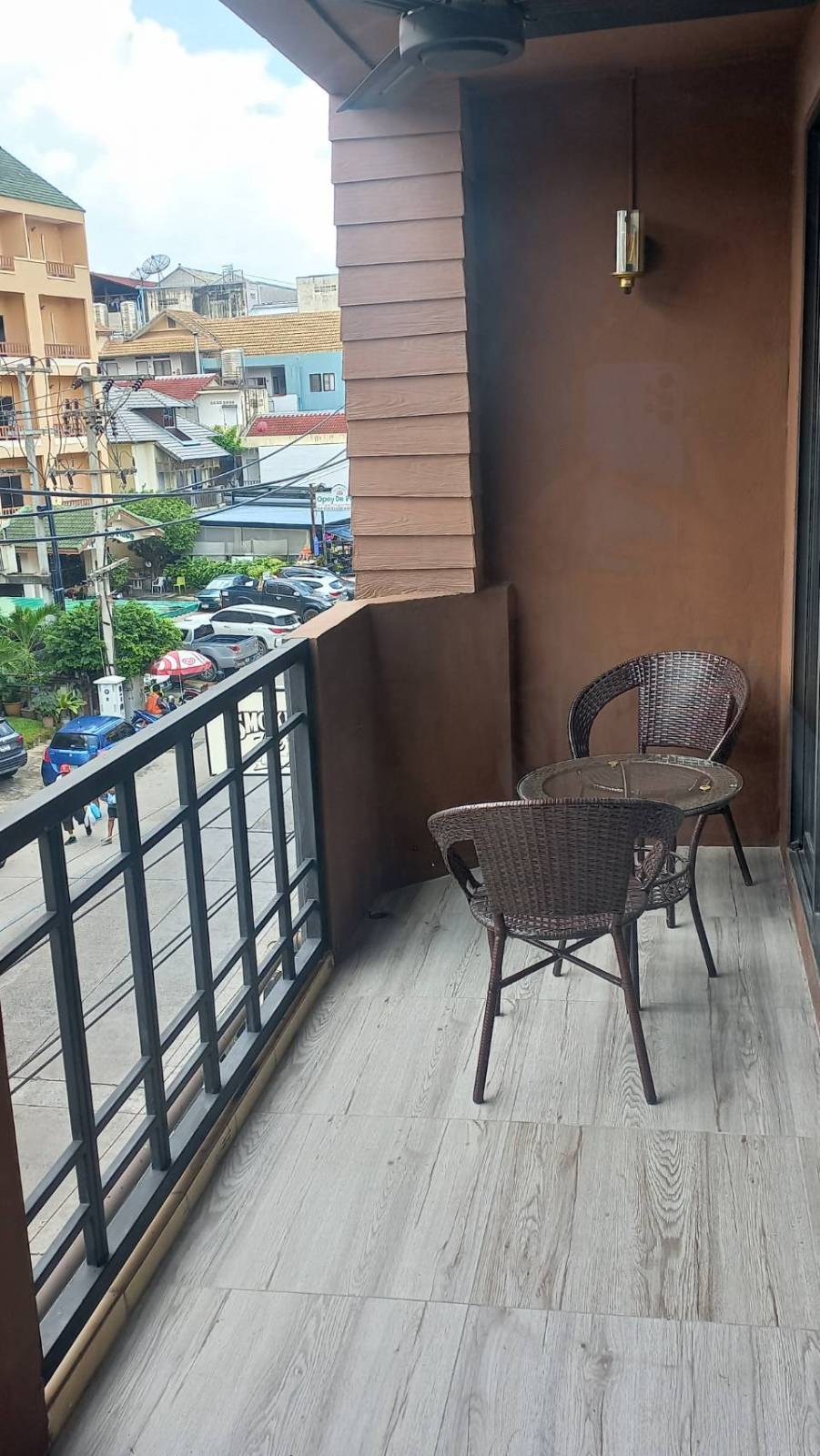 The photographed balcony at Flame with two rattan chairs overlooking Soi Lengkee